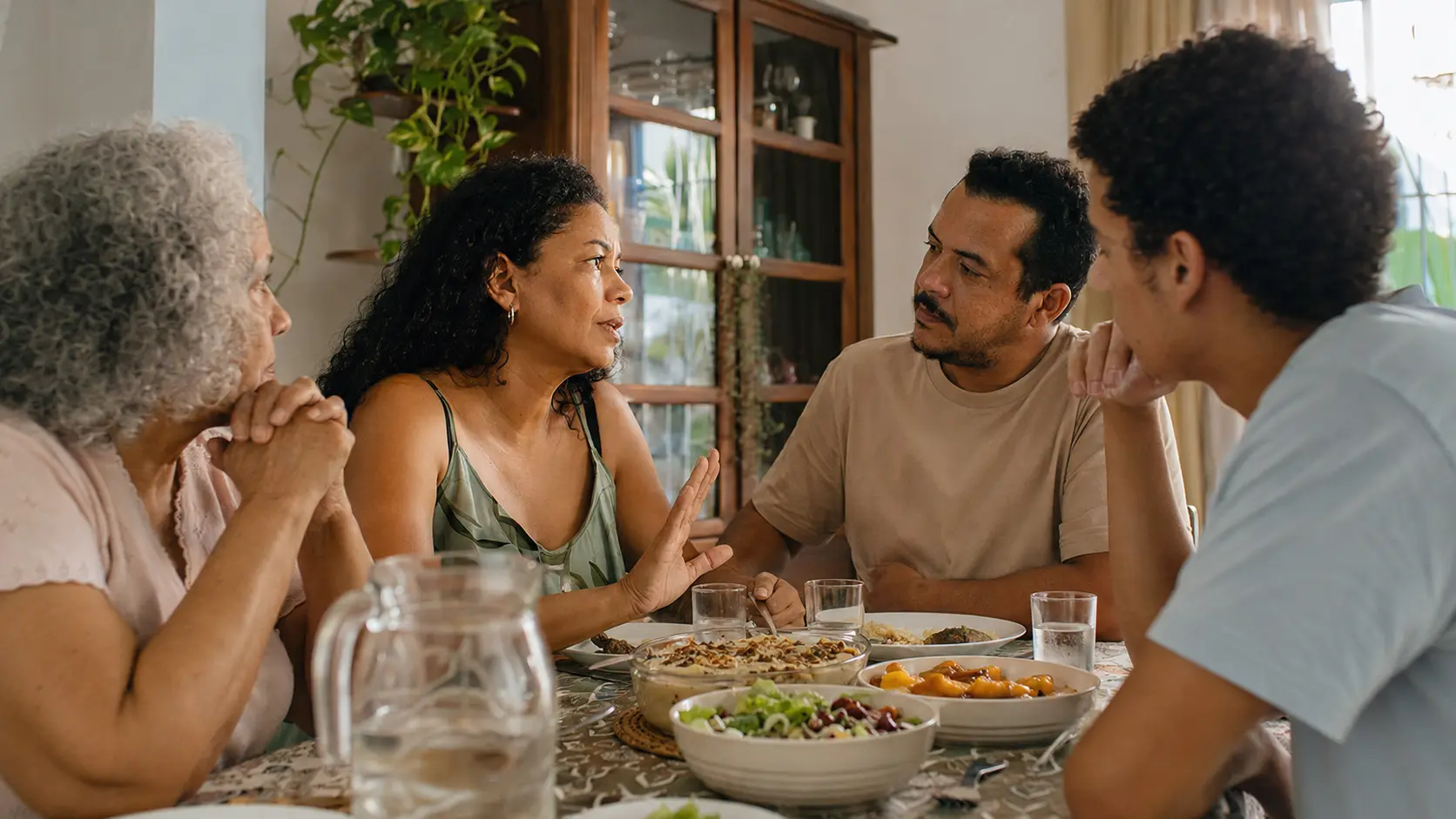 Almoço de família em casa, uma pessoa falando com firmeza enquanto os outros param a conversa